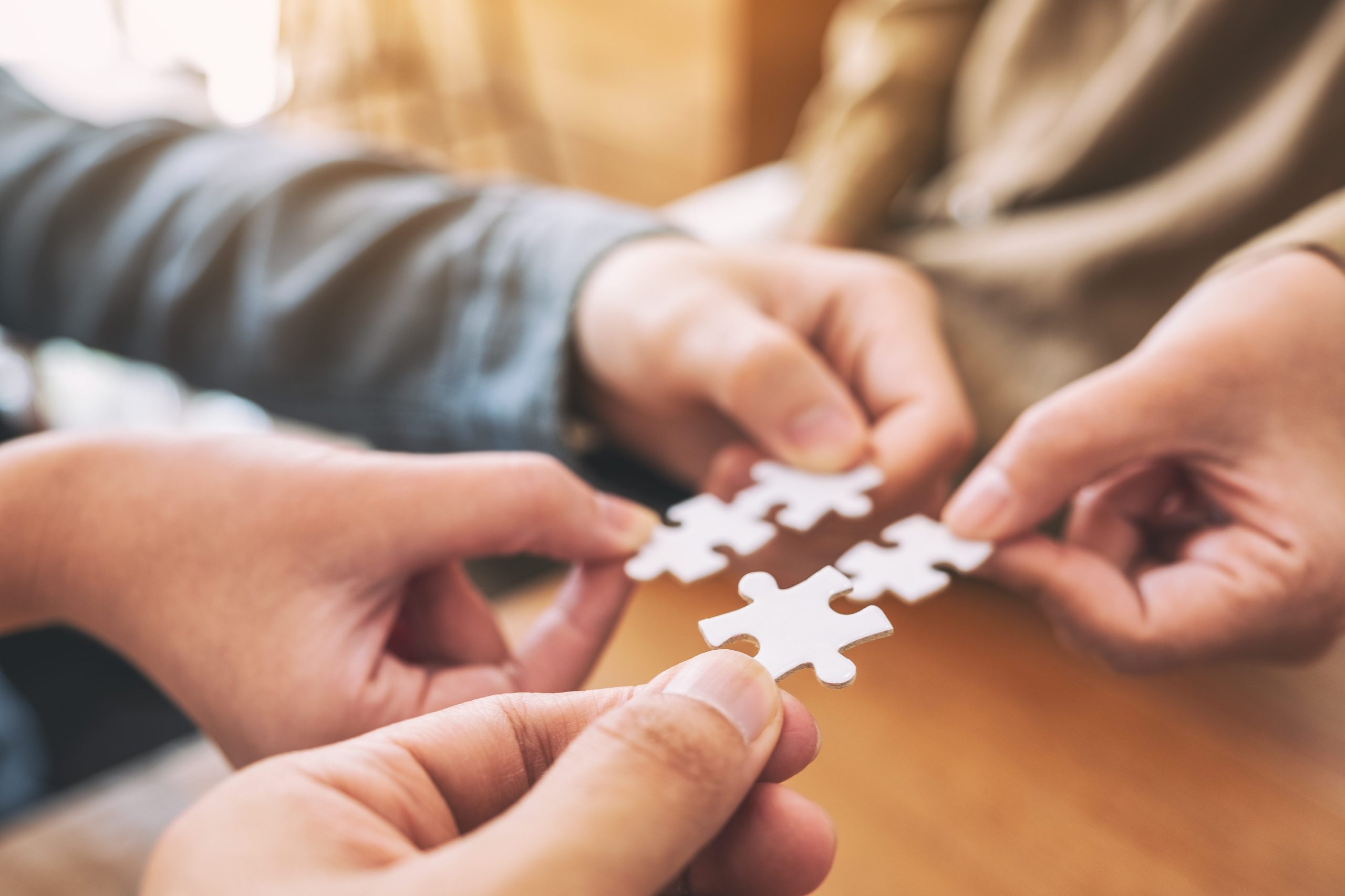 Closeup image of people's hands holding and putting a piece of w
